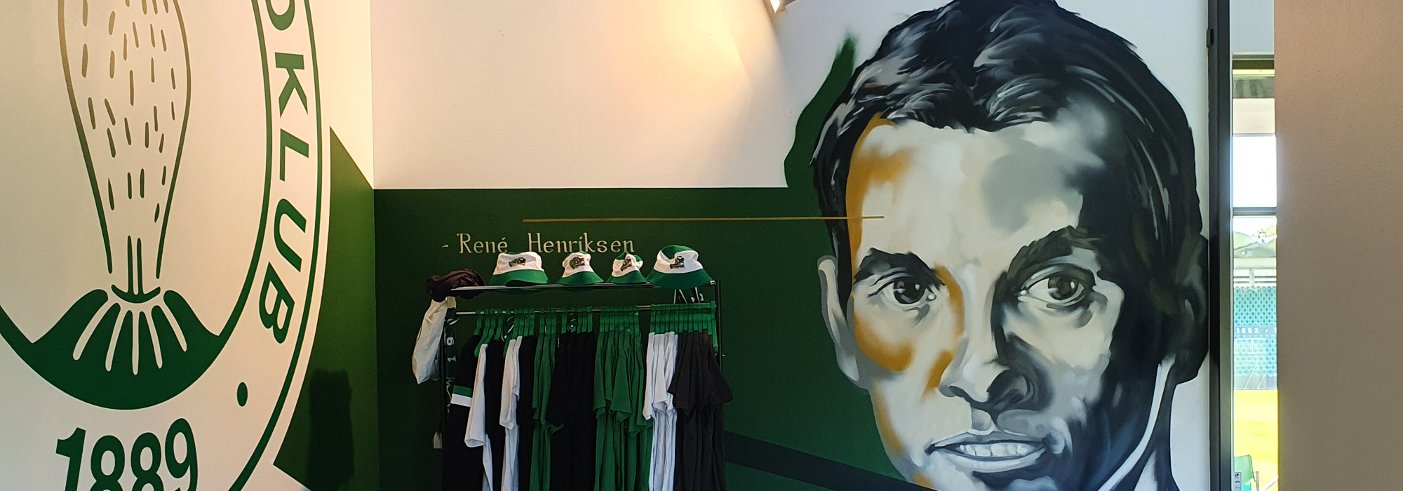 Graffiti kunstner Jakob i maler vægmalerier og udsmykker fancaféen for Akademisk Boldklub på Gladsaxe Stadion