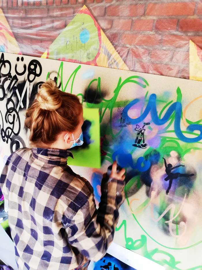 Pige øver sig i at male graffiti