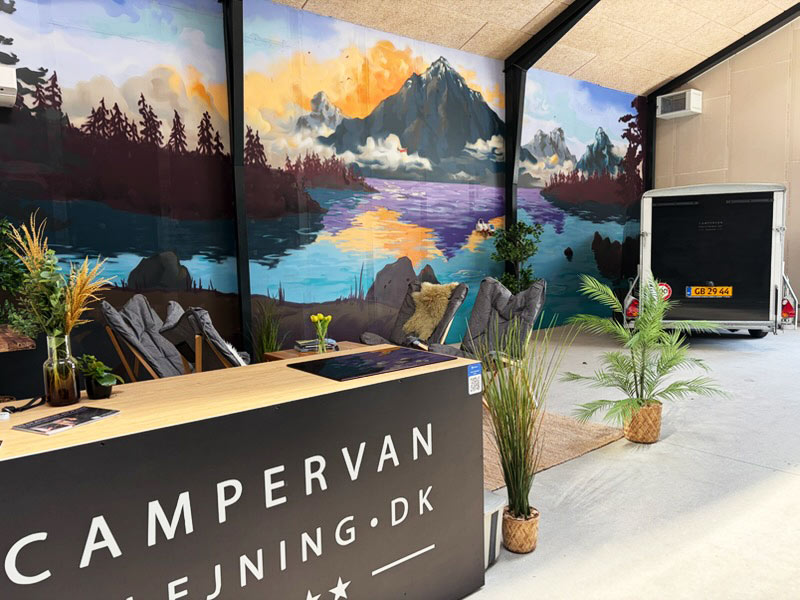 Vægmaleri med bjerge og sø som udsmykning i showroom lavet til firmaet Campervan på Fyn